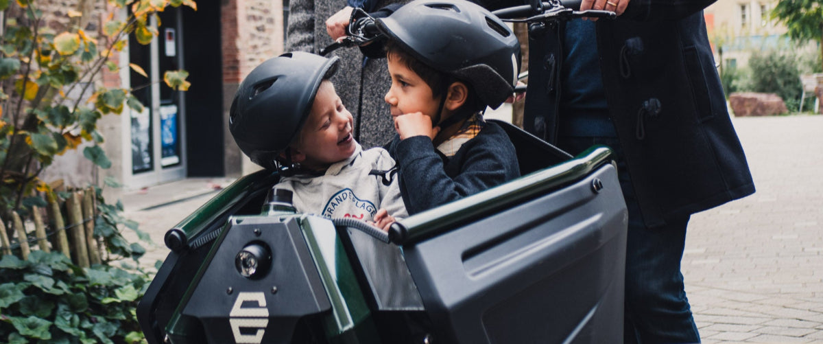 deux enfants à l'avant du vélo cargo le formidable