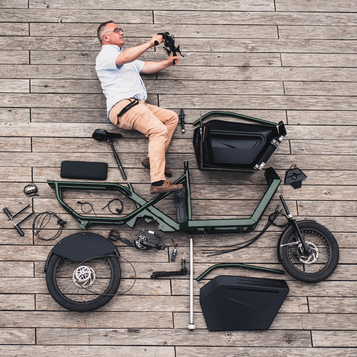 Photo vue de dessus d'un homme avec le vélo en pieces détachées autour de lui
